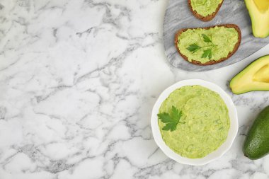 Beyaz mermer masa üzerinde guacamole, sandviç ve avokado ile düz yatıyordu kompozisyon. Metin için alan