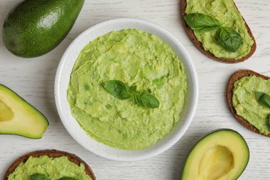 Beyaz ahşap masa üzerinde guacamole, sandviç ve avokado ile Düz yatıyordu kompozisyon