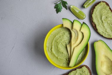 Gri masada olgun avokado yapılmış guacamole kase ile düz yatıyordu kompozisyon. Metin alanı