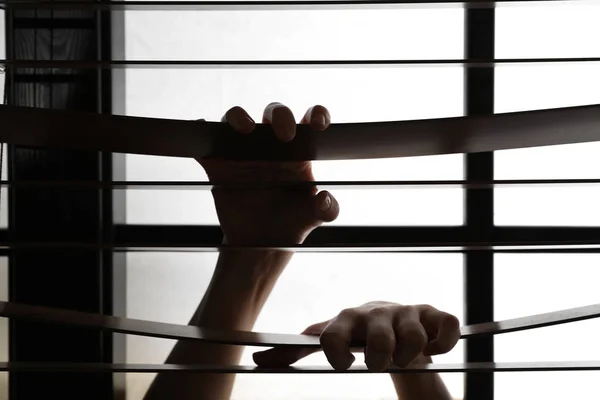 Kobieta trzymanie się żaluzji okiennych, zbliżenie. Zatrzymaj przemoc — Zdjęcie stockowe