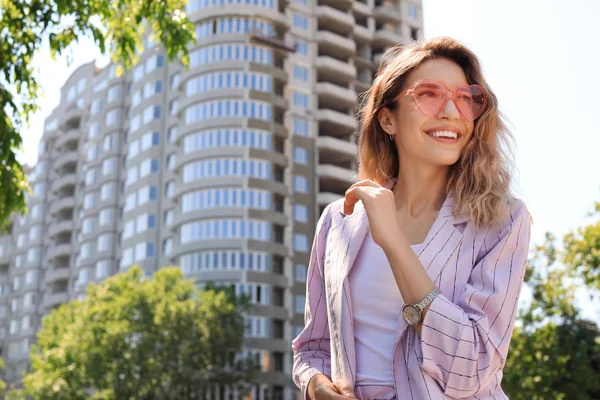 Πορτραίτο της ευτυχης νεαρής γυναίκας με γυαλιά σε σχήμα καρδιάς στην πόλη την ηλιόλουστη μέρα. Χώρος για κείμενο — Φωτογραφία Αρχείου