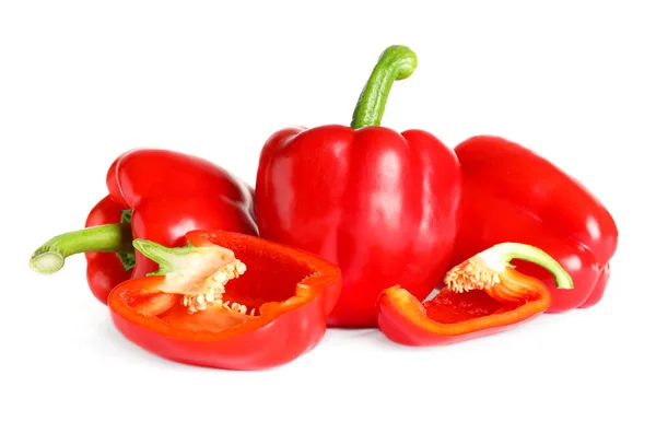 Geschnittene und ganze reife rote Paprika auf weißem Hintergrund — Stockfoto