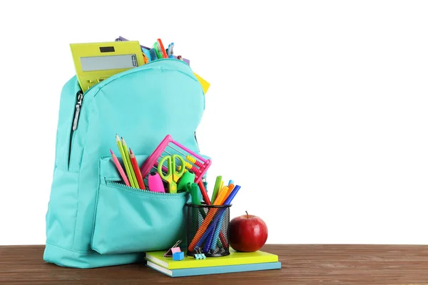 Mochila brillante con papelería escolar sobre mesa de madera marrón sobre fondo blanco, espacio para texto —  Fotos de Stock