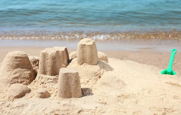 Pequenas figuras de areia na praia perto do mar. Espaço para texto — Fotografia de Stock