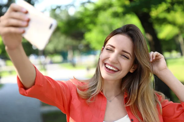 Joyeux jeune femme prenant selfie dans le parc — Photo