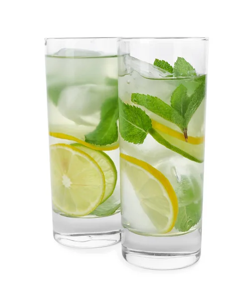 Vasos de bebida refrescante con rodajas de cítricos y menta sobre fondo blanco —  Fotos de Stock