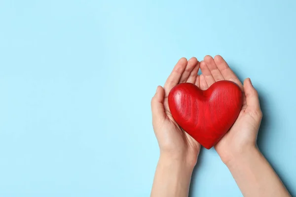 Mujer sosteniendo el corazón sobre fondo azul, vista superior con espacio para el texto. Concepto de donación —  Fotos de Stock