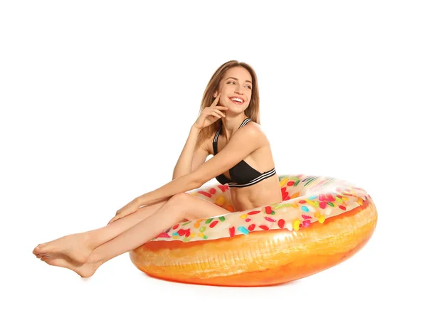 Hermosa mujer joven en bikini elegante con anillo inflable de rosquilla sobre fondo blanco — Foto de Stock