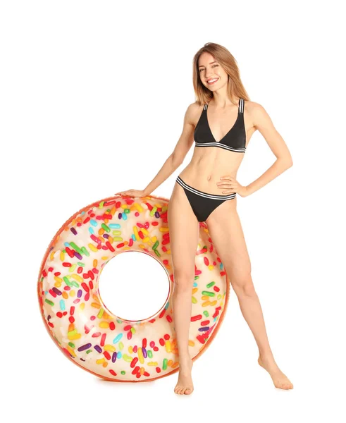 Mooie jonge vrouw in stijlvolle bikini met donut opblaasbare ring op witte achtergrond — Stockfoto