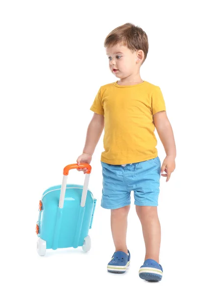 Bonito menino caminhando com mala azul no fundo branco — Fotografia de Stock
