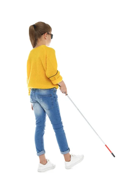 Слепая девушка с длинной тростью ходит на белом фоне — стоковое фото