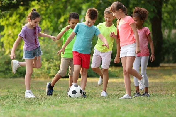 Bonito crianças brincando com bola de futebol no parque — Fotografia de Stock