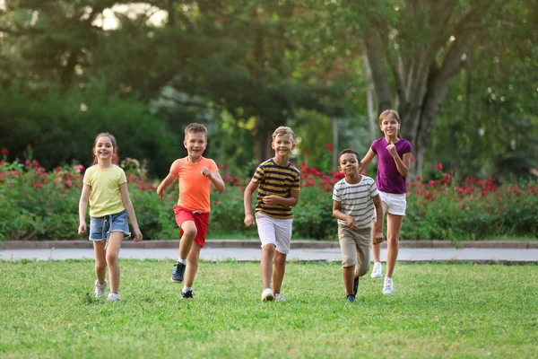 Lindos niños sonrientes jugando en el parque —  Fotos de Stock