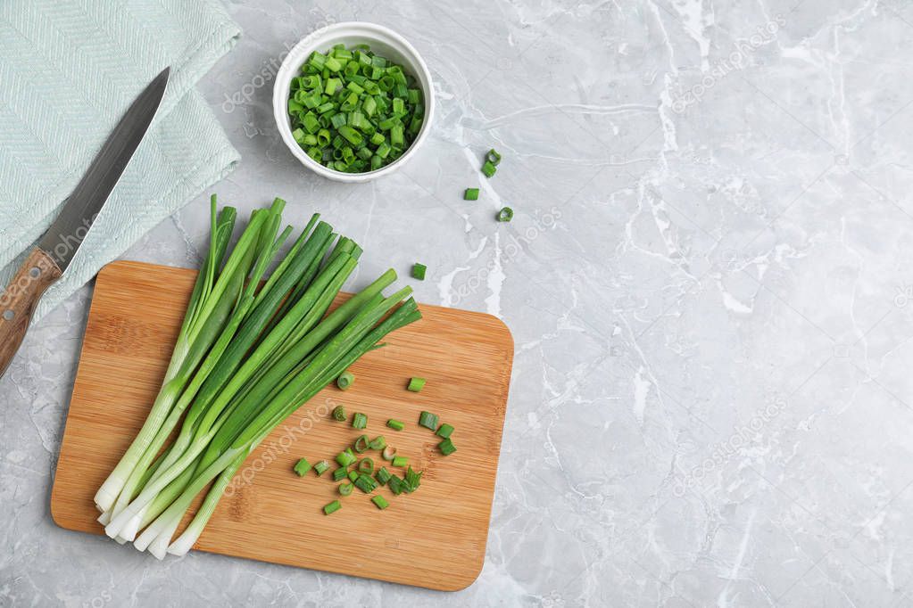 Flat lay composition with fresh green onion on marble background. Space for text