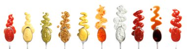 Set of spoons with different delicious sauces on white background, top view clipart