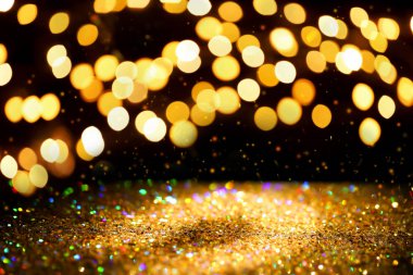 Siyah arka plan üzerinde bokeh etkisi ile altın glitter