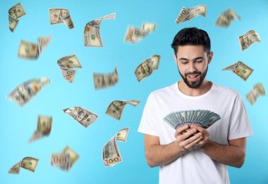 Mavi arka plan üzerinde para yağmur altında dolar ile genç adam