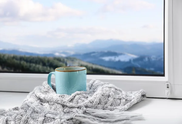 Warme drank en warme sjaal in de buurt van raam met uitzicht op de Winterberg landschap — Stockfoto