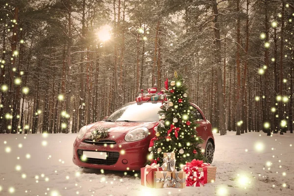 Автомобиль с подарками и венком возле елки в снежном лесу в зимний день — стоковое фото