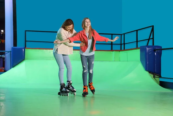 Жінка навчає свою дочку кататися на ковзанах — стокове фото