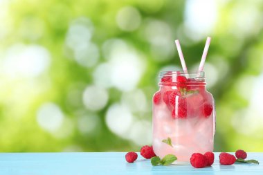 Bulanık arka plan, metin için alan karşı mavi ahşap masada ahududu ferahlatıcı içecek ile Mason kavanoz