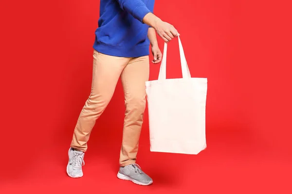 Fiatal férfi öko táska piros háttér, Vértes — Stock Fotó