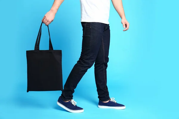 Молодой человек с эко-сумкой на синем фоне, крупным планом — стоковое фото
