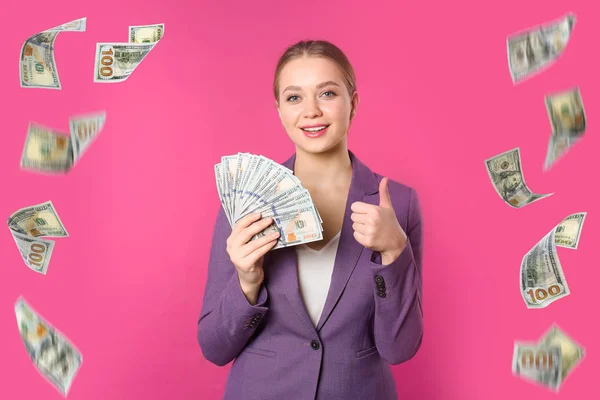 Dolar ve pembe arka plan üzerinde para uçan mutlu genç iş kadını — Stok fotoğraf