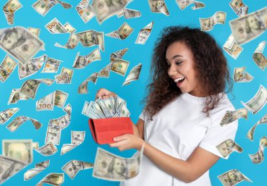 Cüzdan para dolu genç kadın ve mavi arka plan üzerinde uçan dolar