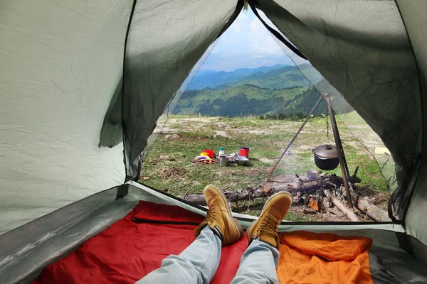 Gros plan de l'homme dans une tente de camping avec des sacs de couchage sur une colline de montagne, vue de l'intérieur — Photo