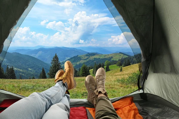 Closeup of people in camping tent with sleeping bags on mountain hill, view from inside — Stock Photo, Image