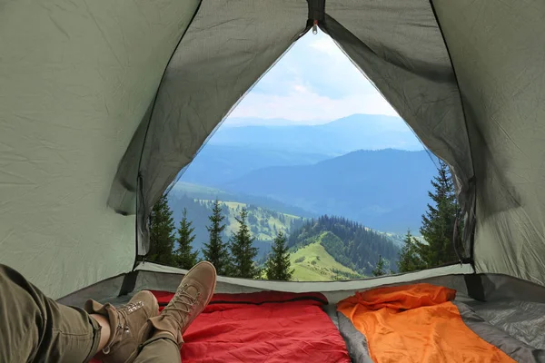 산 언덕에 침낭을 들고 캠핑 텐트에서 여자의 클로즈업, 내부에서 보기 — 스톡 사진