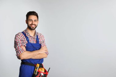Hafif arka planda takım kemeri ile inşaat işçisi portresi. Metin için alan