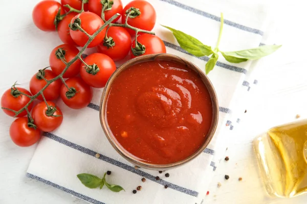 Flache Liegekomposition mit Schüssel mit Sauce und Tomaten auf weißem Tisch — Stockfoto