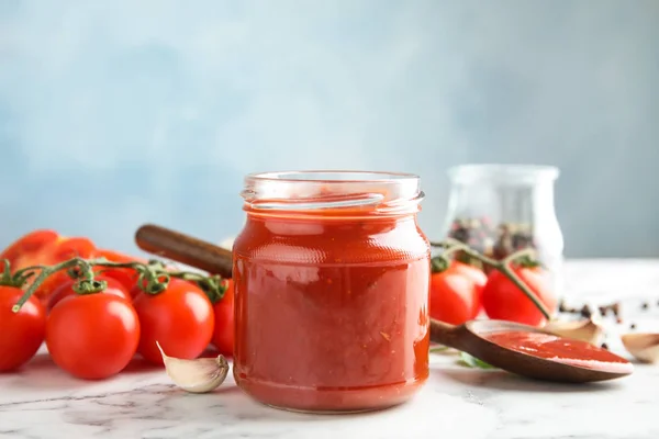 Composition avec pot de sauce tomate savoureuse sur la table sur fond de couleur — Photo