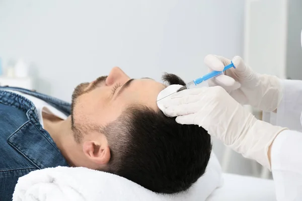 Man with hair loss problem receiving injection in salon — Stock Photo, Image