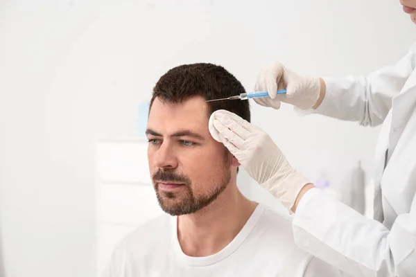 Uomo con problemi di perdita di capelli che riceve l'iniezione nel salone — Foto Stock