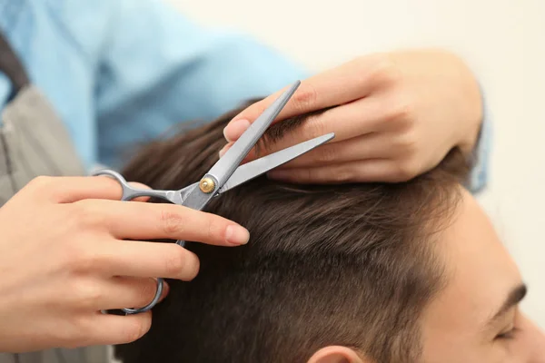 Barbeiro fazendo corte de cabelo elegante com tesoura profissional no salão de beleza, close-up — Fotografia de Stock