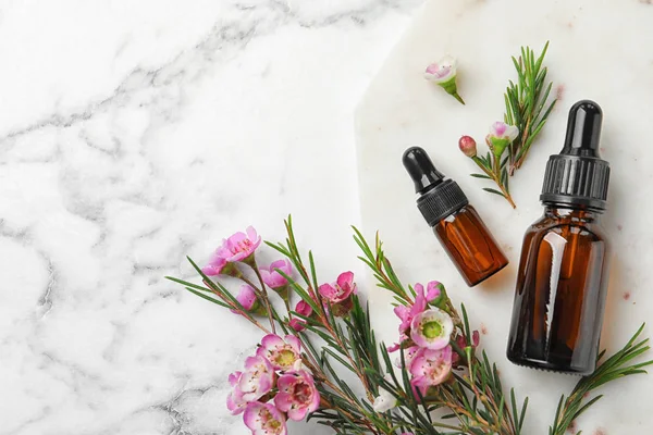 Beyaz mermer arka planda metin için doğal çay ağacı yağı ve boşluk şişeleri ile düz yatıyordu kompozisyon