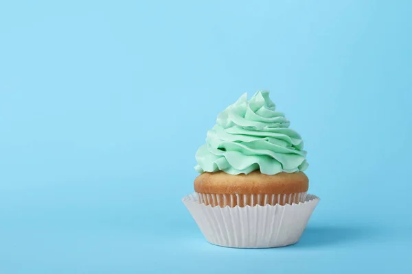 Gâteau savoureux avec crème sur fond bleu clair, espace pour le texte — Photo