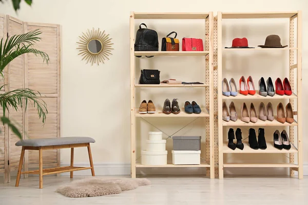 スタイリッシュな部屋のインテリアに異なる靴やアクセサリーを備えた木製の棚ユニット — ストック写真