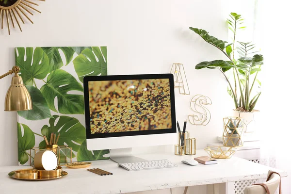Posto di lavoro moderno con computer e arredamento dorato sulla scrivania vicino alla parete. Design d'interni elegante — Foto Stock