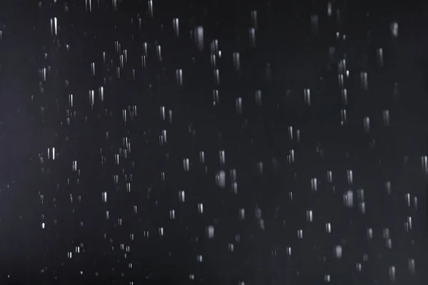 Gotas de lluvia cayendo sobre fondo oscuro — Foto de Stock