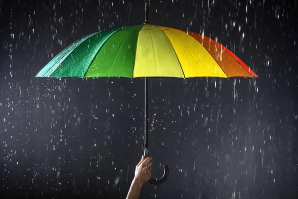 Karanlık arka planda yağmur altında parlak şemsiye tutan kadın, closeup — Stok fotoğraf