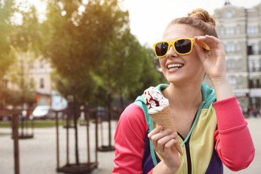 Şehir caddesinde dondurma konisi ile genç mutlu kadın. Metin için alan