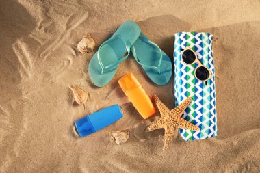 Kum üzerinde şık plaj aksesuarları ile düz döşeme kompozisyon