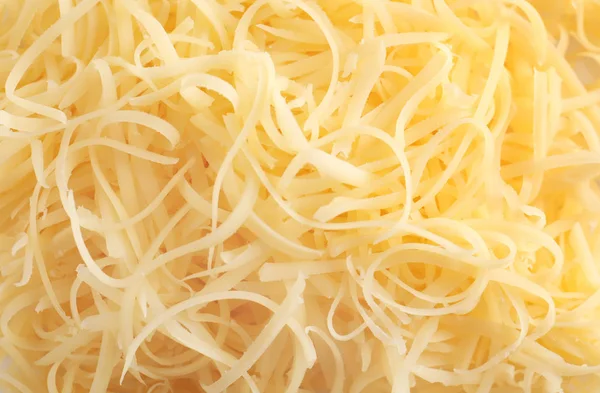Fresco delicioso queso rallado como fondo, primer plano — Foto de Stock