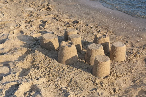 Vista da praia com pequenas figuras de areia perto do mar no dia ensolarado de verão — Fotografia de Stock