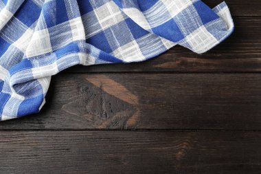 Ahşap masa üzerinde damalı mutfak havlusu, üst görünümü. Metin için alan