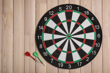 Ahşap arka plan üzerinde renk okları ile dart tahtası, üst görünüm. Metin alanı
